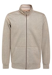 Sudadera con cremallera de color beige claro, con un cuello alto, bolsillos frontales y puños acanalados. Está hecha de un tejido texturizado con un patrón sutil.