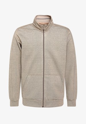 Sudadera con cremallera de color beige claro, con un cuello alto, bolsillos frontales y puños acanalados. Está hecha de un tejido texturizado con un patrón sutil.
