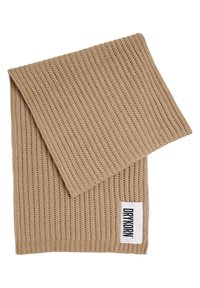 Écharpe beige en tricot avec motif côtelé, pliée, avec une étiquette rectangulaire blanche portant le texte "DRYKORN" en noir.