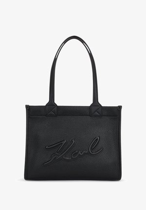 Svart tote bag laget av teksturert lær med en hevet "Karl"-logo på forsiden. Har to solide håndtak og forsterkede hjørner.
