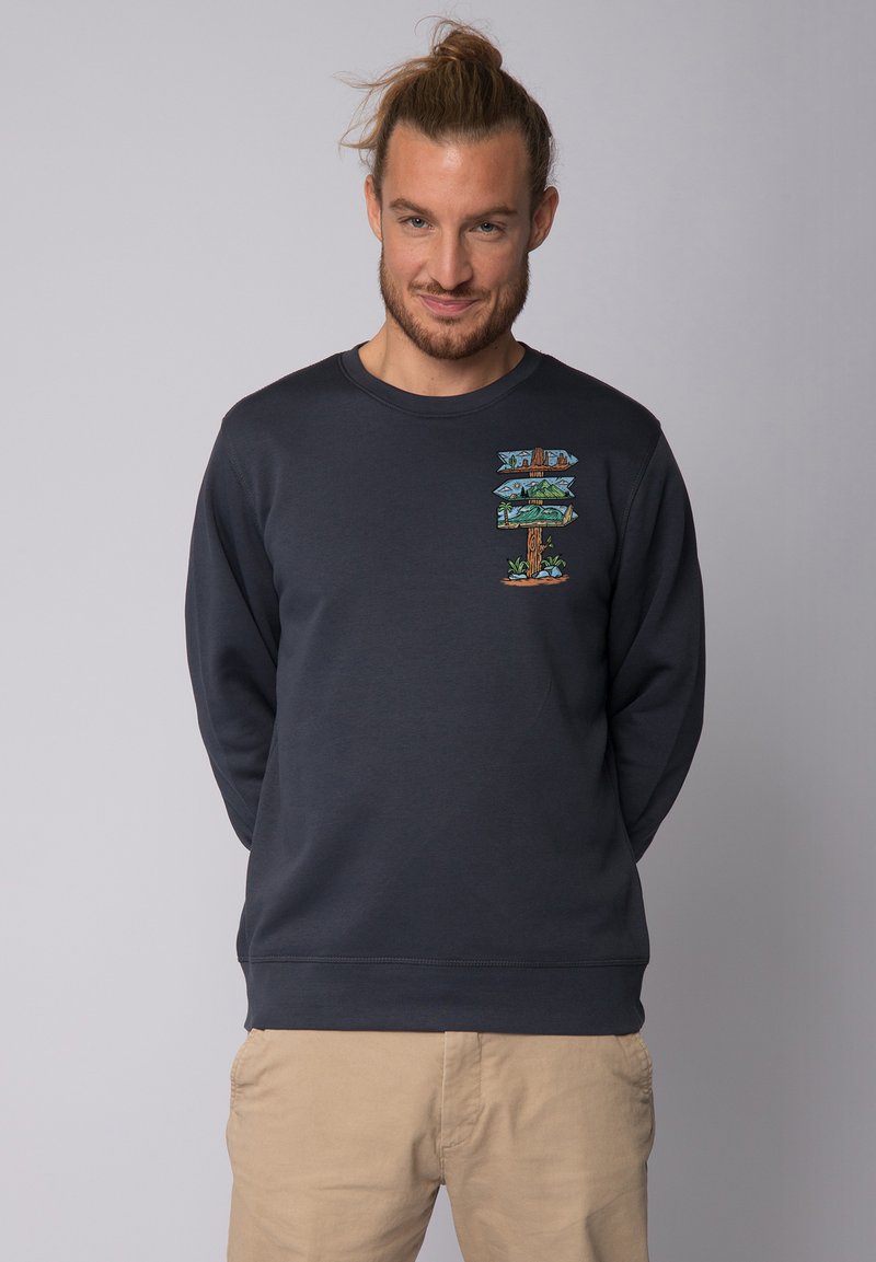 Dunkelblaues Sweatshirt mit einem grafischen Design von Richtungsschildern, Bäumen und Landschaften. Hergestellt aus weichem Stoff mit Rundhalsausschnitt.
