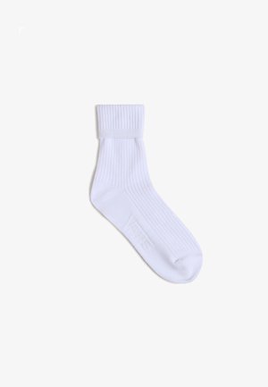 Valkoinen puuvillasukka, jossa on ribbikuvio, yksivärinen ja pehmeä varsi. Sivulle on painettu logo brändäystä varten.