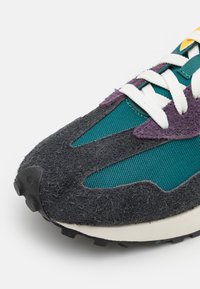 Sneakers med överdel i svart mocka, akenter i teal mesh och lila detaljer. Har vita snören och en strukturerad svart gummisula.