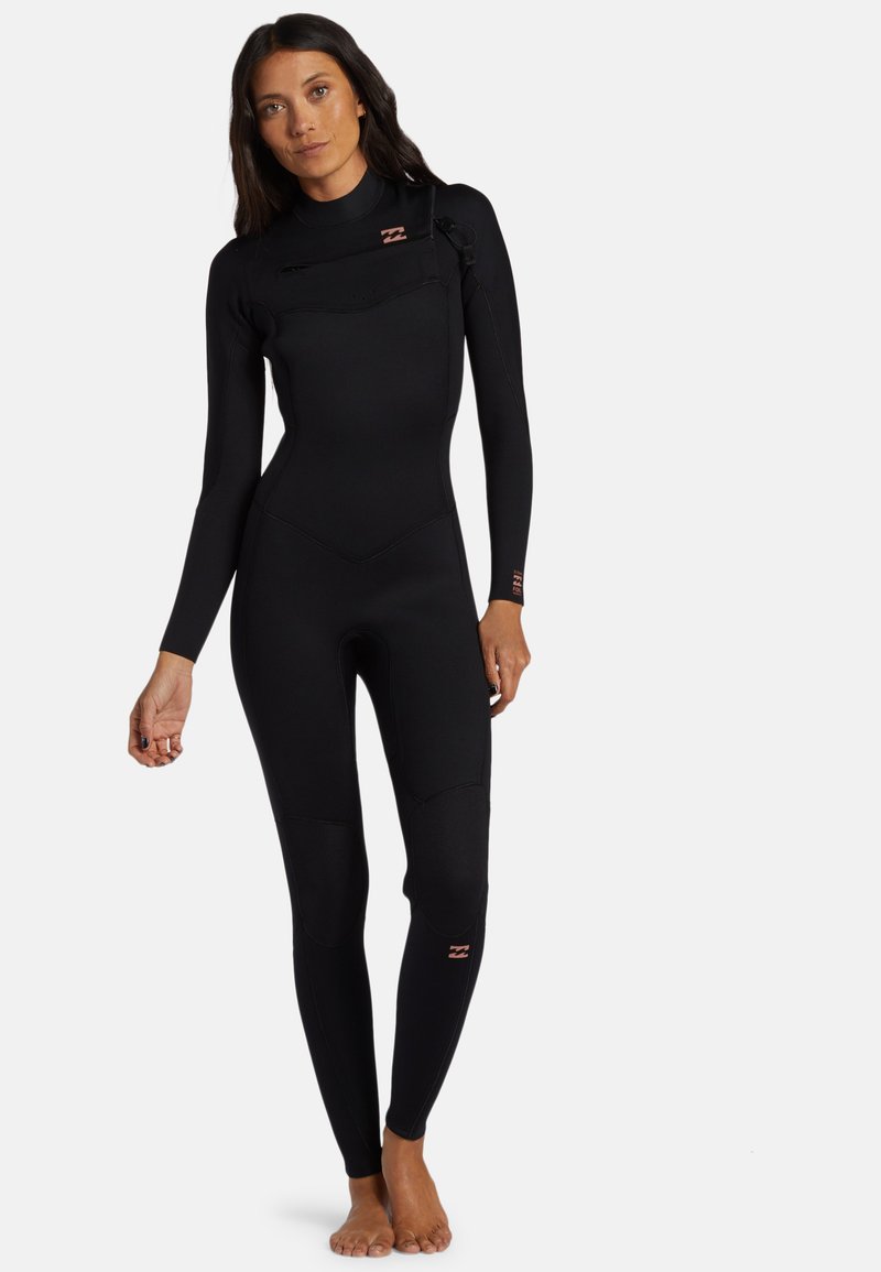 Muta nera con maniche lunghe, design senza cuciture, zip sul petto e gambe aderenti. Presenta un logo rosa sulla manica e sulla coscia.