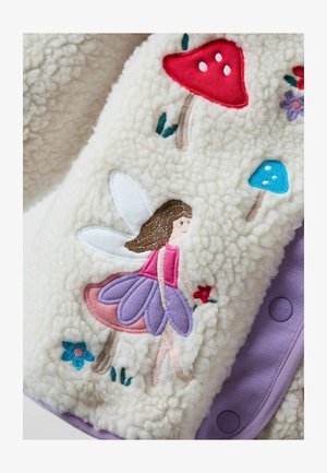 Jachetă din blană de miel crem, cu un monstru brodat pe un ciupercă, ciuperci roșii și albastre, accente mov și închidere cu nasturi.