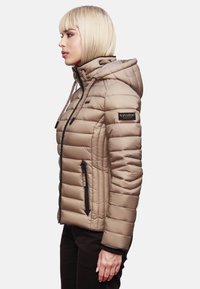 Beige puffjakke med horisontale sømmer, hette og brune detaljer. Har frontlommer med glidelås og et logo-patch på skulderen.