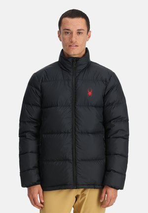 Schwarze Daunenjacke mit hohem Kragen, ausgestattet mit einem roten Spinnenlogo auf der linken Brust, Reißverschluss und gestepptem Design zur Isolierung.