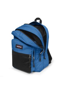 Mochila azul con un bolsillo frontal de malla negra, cremalleras dobles, correas acolchadas y un asa superior. Compartimento principal espacioso con un diseño estructurado.