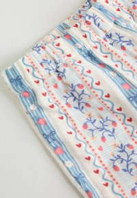 Materiał wzorzysty z niebieskimi paskami, kwiatowymi motywami, sercami i małymi kokardkami. Miękka tekstura o lekkim, zwiewnym wyglądzie.