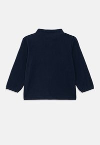 Χειμερινό μπλε ναυτικού φλις με μακριά μανίκια και ψηλό γιακά. Μαλακή υφή, casual σχέδιο, χωρίς εμφανείς κλεισίματα ή διακοσμήσεις.