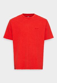 T-shirt rosso a maniche corte con colletto tondo e discreto logo Levi's ricamato sul lato sinistro del petto.