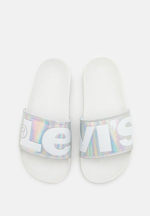 Sandalias tipo chancla blancas con una tira iridiscente que lleva el logo "Levi's" en letras blancas y llamativas. Suela suave con textura lisa.