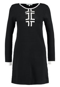 Černé dlouhé šaty s bílým lemem na límci, manžetách a dvěma vodorovnými bíle pruhovanými zapínáními na hrudi.