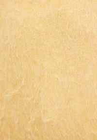 Tissu tricoté jaune au toucher doux et pelucheux, présentant un tissage fin et de subtiles variations de ton. Idéal pour des vêtements chauds.