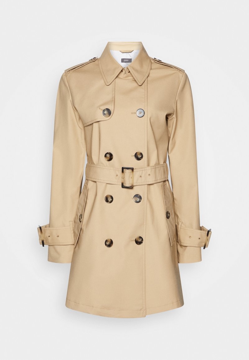 Trench-coat beige croisé avec ceinture, poignets boutonnés, épaulettes et poches avant en biais sur un fond uni.