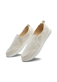 Beige Slipper-Schuhe verfügen über ein strukturiertes Obermaterial, einen weichen Stoff und eine weiße Gummisohle. Eine Akzent-Schlaufe an der Ferse erleichtert das An- und Ausziehen.