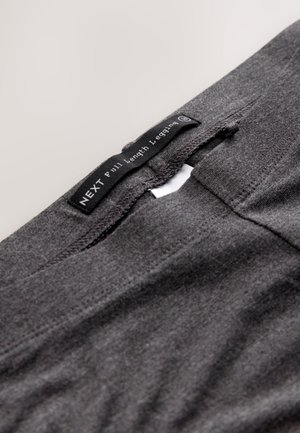 Leggings grigi a lunghezza intera con una texture liscia e un'etichetta in vita, con il marchio "NEXT" e i dettagli del prodotto.