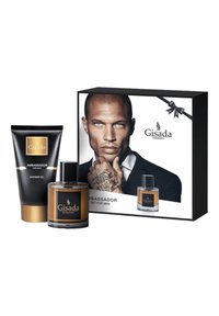Le set Gisada Ambassador comprend un tube de gel douche noir, une bouteille de parfum en verre brun et un emballage en boîte présentant un modèle et le logo de la marque.
