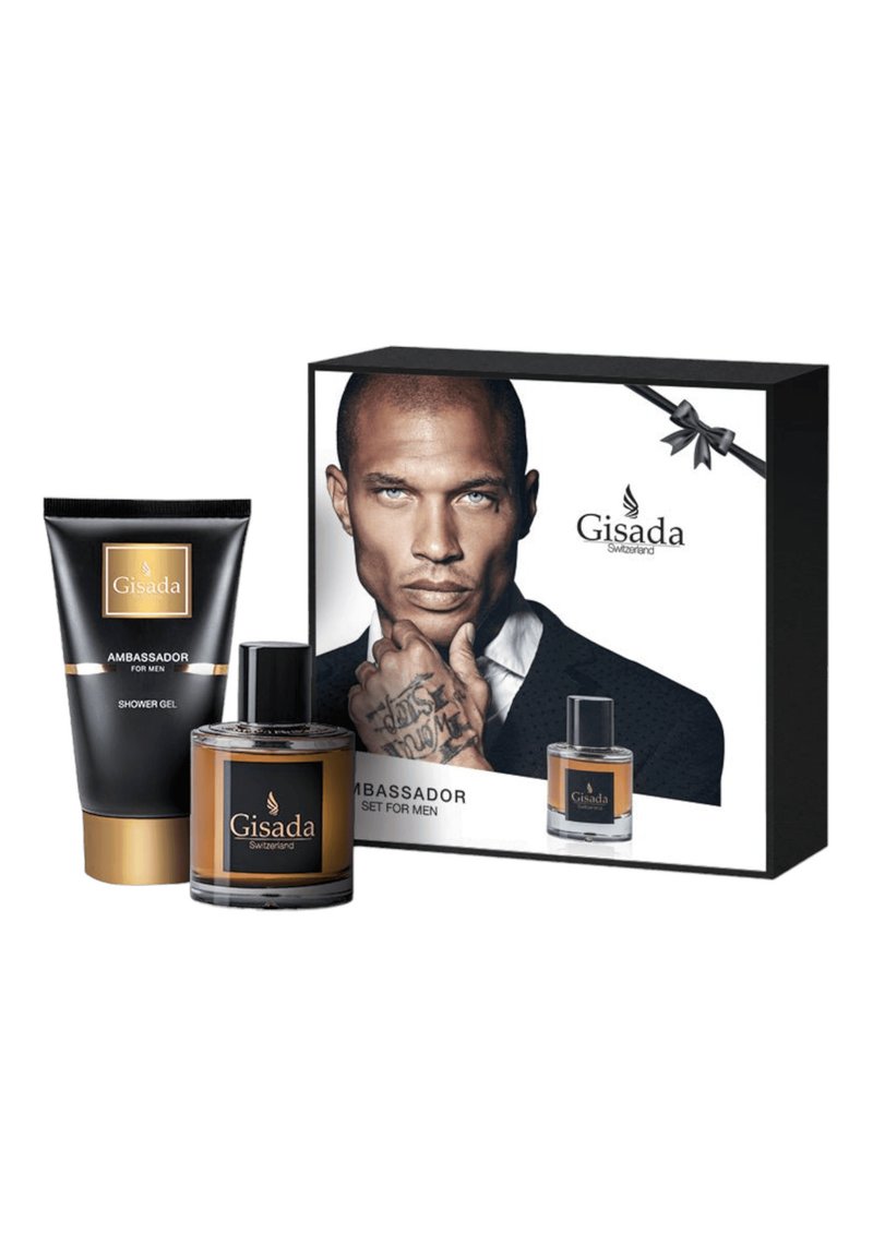 Le set Gisada Ambassador comprend un tube de gel douche noir, une bouteille de parfum en verre brun et un emballage en boîte présentant un modèle et le logo de la marque.