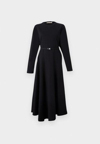 Μαύρο φόρεμα με μακριά μανίκια, στρογγυλή λαιμόκοψη, ζώνη στη μέση και φούστα μέχρι το πάτωμα με διαγώνιες ραφές. Ομαλή υφή υφάσματος.