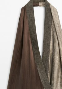 Robe marron et beige avec col texturé et tissu drapé montrant des matériaux lisses et à motifs.