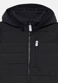 Svart puffervest med horisontalt quiltet design, frontglidelås og hette. Pyntet med sølvfargede detaljer og en glidelåslomme.