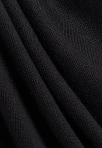 Zwarte gebreide stof met een zachte textuur, die een close-upweergave toont van het patroon van de weving en de vallende plooien.