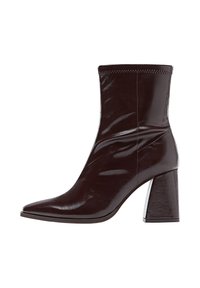 Stivale alla caviglia in vernice marrone con punta affusolata, risvolto cucito in texture e tacco alto e chunky. Superficie sleek e liscia con finitura lucida.