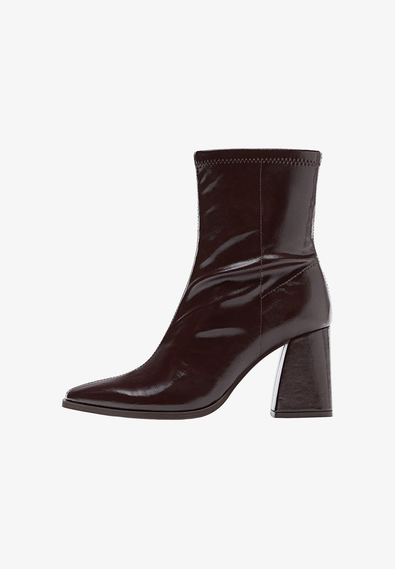 Bottine en patent marron avec un bout pointu, un poignet texturé cousu et un talon épais et haut. Surface lisse et élégante avec une finition brillante.