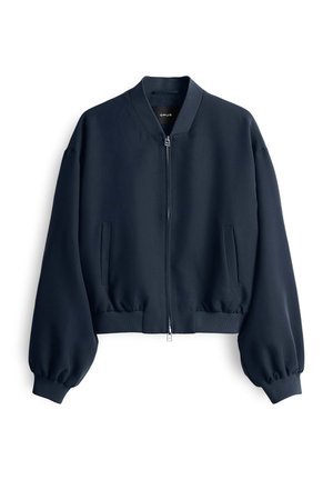 Giacca bomber cropped blu navy con maniche lunghe a sbuffo, polsini a coste e chiusura frontale con zip. Presenta tasche laterali e una texture liscia.