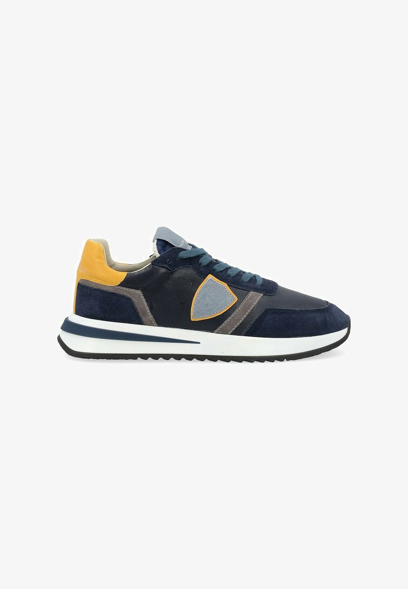 Sneaker da uomo in pelle scamosciata e pelle blu navy, con dettagli grigi e gialli. Presenta un colletto imbottito, suola in gomma e un logo distintivo sui lati.