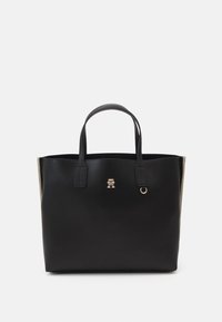 Borsa a tote in pelle nera con hardware logo dorato, manici piatti e un'accents in tessuto testurizzato sui lati. Forma rettangolare con apertura superiore.