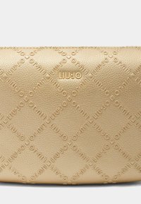 Borsa in pelle beige Liu Jo con motivo a diamante impresso, con il nome del marchio in hardware dorato sul fronte. Texture liscia.