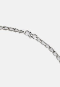 Sølvmetal kædedesign med en simpel kroklås, der har en glat overflade og ensartede ovale led, som er tæt forbundet.