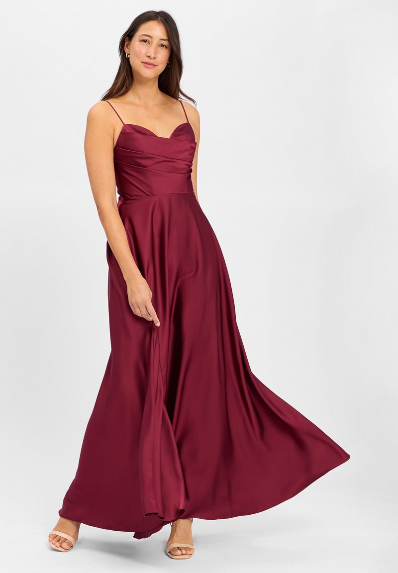 Robe maxi en satin bordeaux avec un décolleté en cœur, des fines bretelles et une jupe évasée. Texture lisse, idéale pour les occasions formelles.