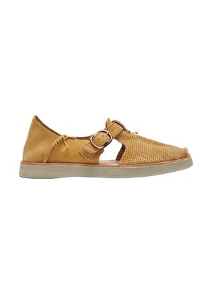 Sandalia de cuero marrón claro con puntera perforada, tira ajustable con hebilla y suela beige plana sobre fondo blanco.