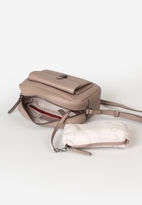 Borsa a tracolla in pelle beige con una piccola pochette staccabile. La borsa presenta una chiusura con zip, una texture liscia e rivestimento interno rosso a contrasto.