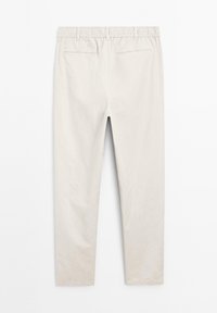 Light beige tapered pants with an elastic waistband, featuring two back pockets and a smooth, matte texture.