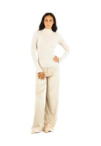 Pullover a collo alto ribbed beige chiaro abbinato a pantaloni a gamba larga in corduroy beige, con una texture liscia e un design aderente.