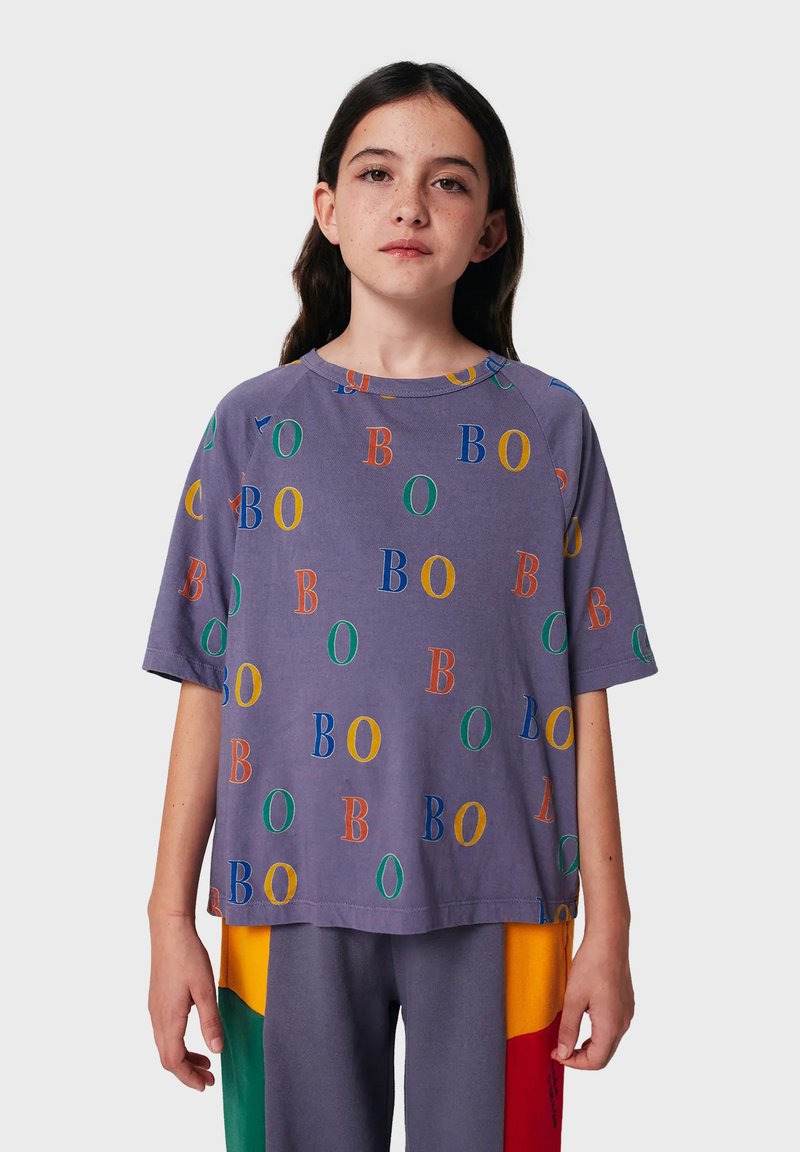 Fialové tričko s krátkým rukávem, zdobené barevnými písmeny "B" a "O" v náhodném uspořádání. Volný střih s kulatým výstřihem.