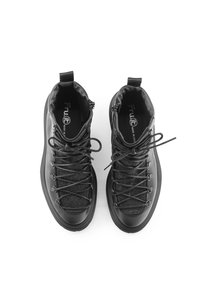 Scarpe alte nere con tomaia in tessuto testurizzato, punta rinforzata e suola in gomma resistente, dotate di lacci a contrasto e di un'etichetta per il tiraggio.