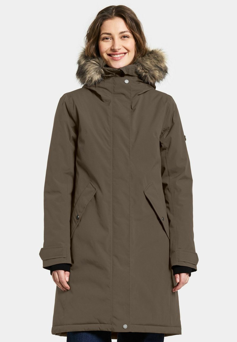 Brun vandtæt parka med hætte foret med pels, frontlynlås, sidelommer og knapdetaljer. Tekstureret stof, knælangt design.