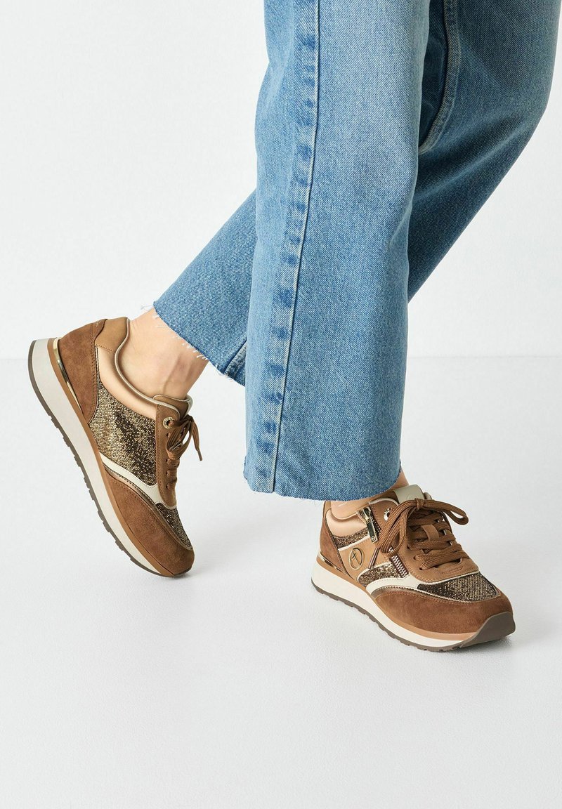 Bruine sportieve sneakers met een combinatie van suède en metallic gaas, voorzien van een witte tussenzool en gestructureerde accenten. Verstelbare veters.