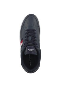 Sneaker sintetico blu navy con design perforato, punta rotonda, suola bianca e dettagli a strisce rosso-bianco-blu sul lato. Logo del brand sulla linguetta.