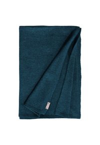 Coperta in maglia verde acqua, di forma rettangolare, morbida al tatto, con un angolo ripiegato e un piccolo etichetta sul bordo.