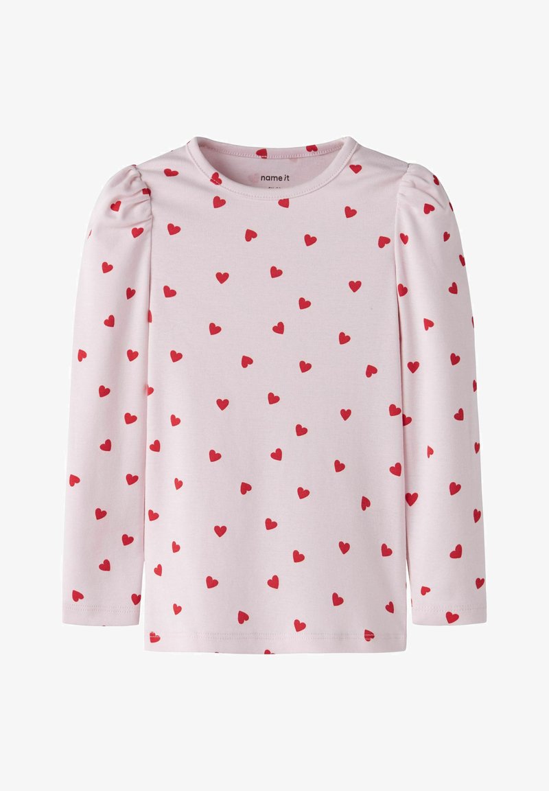 Chemise rose à manches longues pour enfants avec un petit motif de cœurs rouges et un léger détail de fronce sur les épaules.