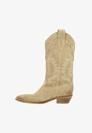 Beige suède cowboylaars met een spitse neus, decoratieve stiksels en een lage gestapelde hak. Bevat accenten in westerse stijl en een trekband.