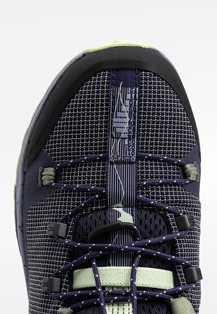 Granatowe buty sportowe z teksturowanym cholewką, odblaskowymi akcentami i czarnym gumowym czubkiem. Cechują się kontrastującymi sznurowadłami i detalami z siateczki.