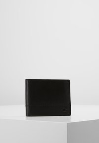 Portefeuille en cuir noir au design simple, mettant en avant un détail de couture et un accent de logo sur un côté. Forme rectangulaire compacte.