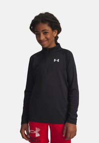 Sort langærmet zip-up skjorte med høj krave og hvid Under Armour-logo på brystet, lavet af et glat, let materiale.